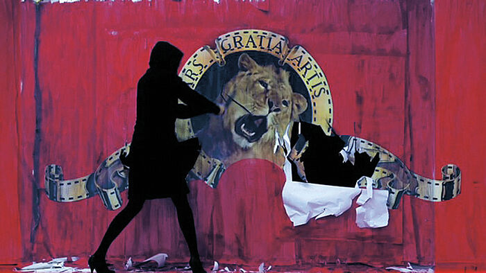 Person reißt Plakat mit Löwenkopf ab