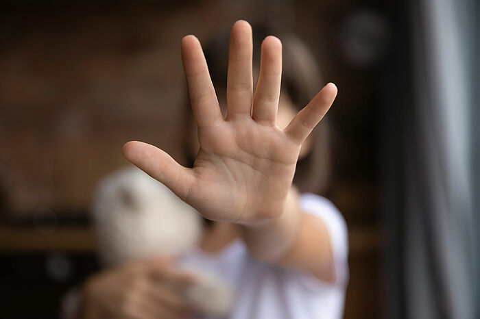 Eine ausgestreckte Kinderhand zeigt Stop
