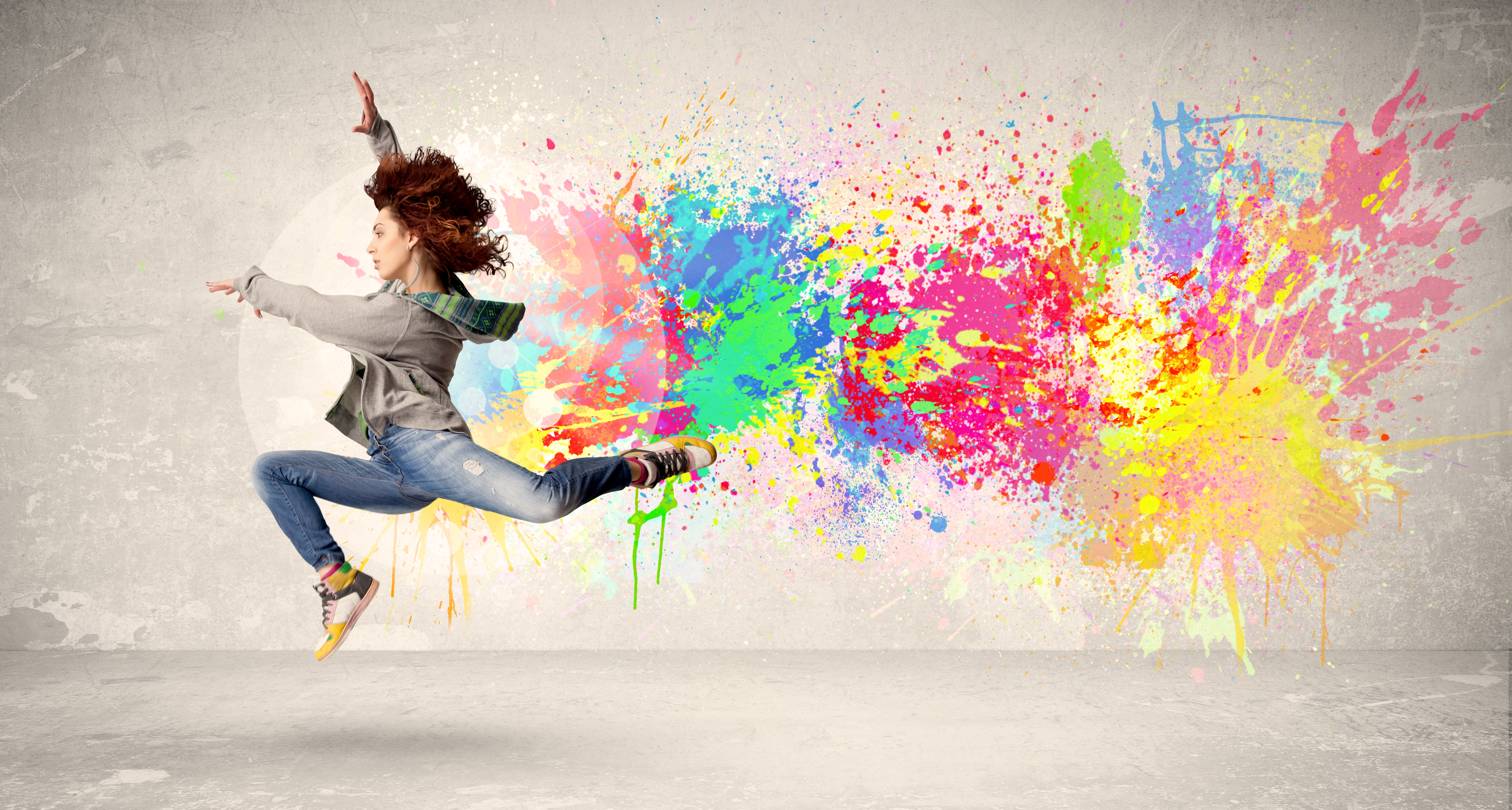 ein Teenager bei einem Tanzsprung vor einem Hintergrund mit bunten Farben
