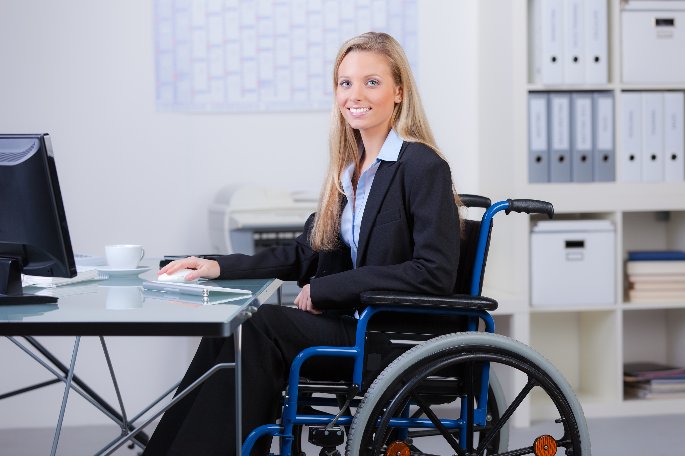 Frau im Rollstuhl am Arbeitsplatz