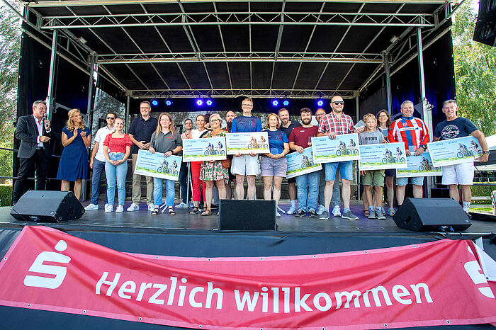 Viele Leute auf einer Bühne bei einer Siegerehrung.