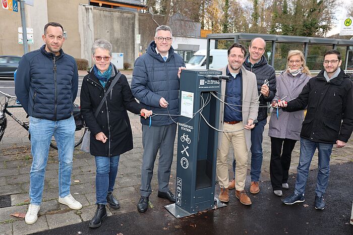 Mehrere Leute neben einem Automaten mit Werkzeug für Fahrräder.