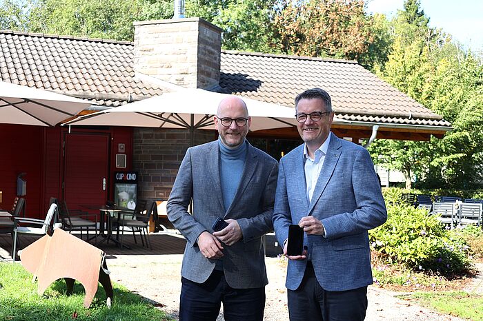 Zwei Männer mit Handys in der Hand.