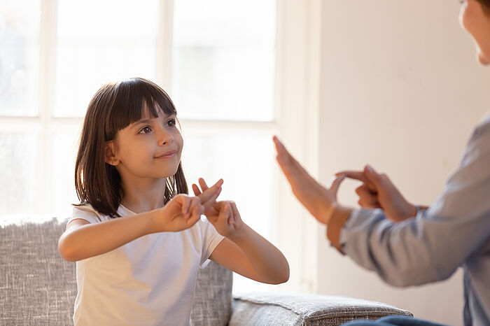 Kleines Mädchen erlernt von einer Frau Gebärdensprache