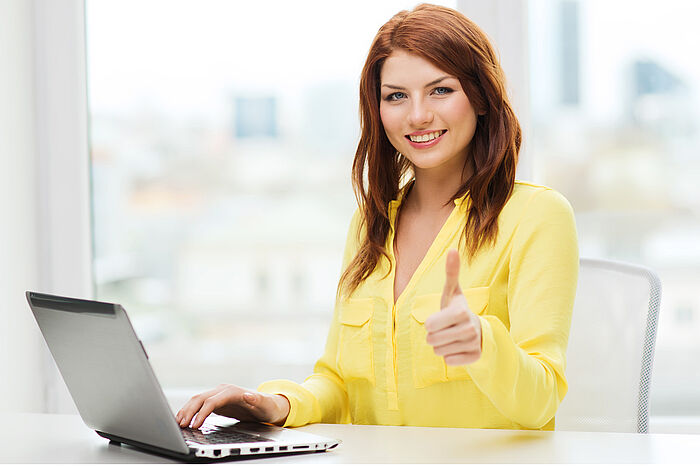 Frau sitzt vor Laptop