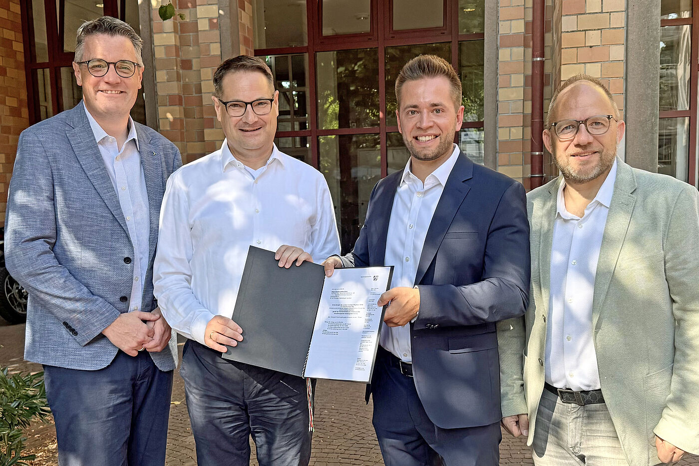 (Von links): Städteregionsrat Dr. Tim Grüttemeier, AKM-Prokurist Ralph Leroy, AKM-Geschäftsführer Marvin Kouchen und Bürgermeister Roger Nießen freuen sich über den Millionen-Bescheid aus Düsseldorf.
