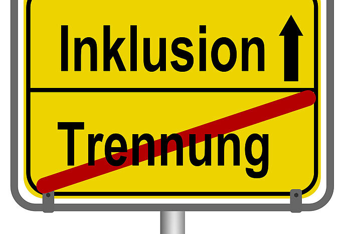 Schild mit Aufschrift "Inklusion" und durchgestrichen ist das Wort "Trennung"