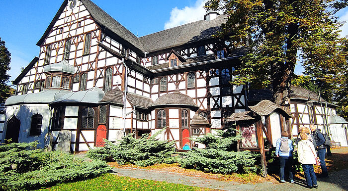 eine Reisegruppe schaut ein historisches Fachwerkhaus in Polen an
