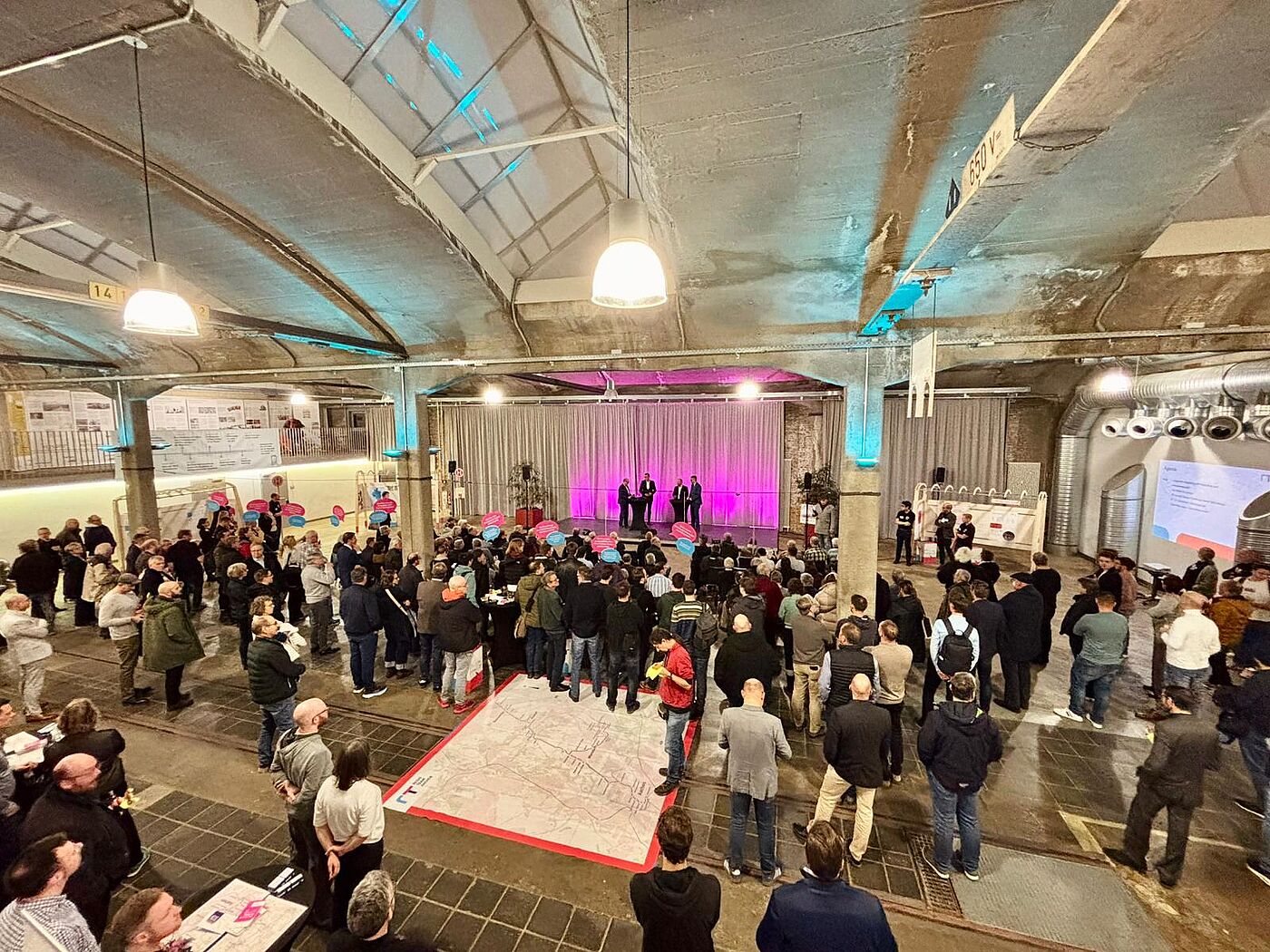 Viele Menschen in einer Wagenhalle