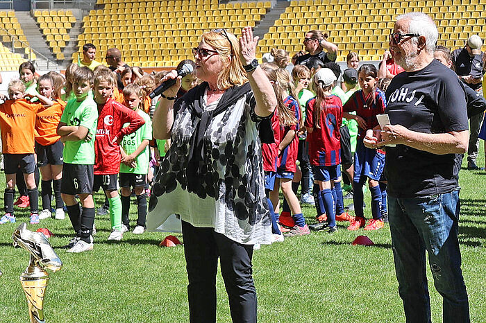 Die stellvertretende Städteregionsrätin Marie-Theres Sobczyk und Stadionsprecher Robert Moonen bei der Siegerehrung der Städteregionsmeisterschaft der Grundschulen im Tivoli.
