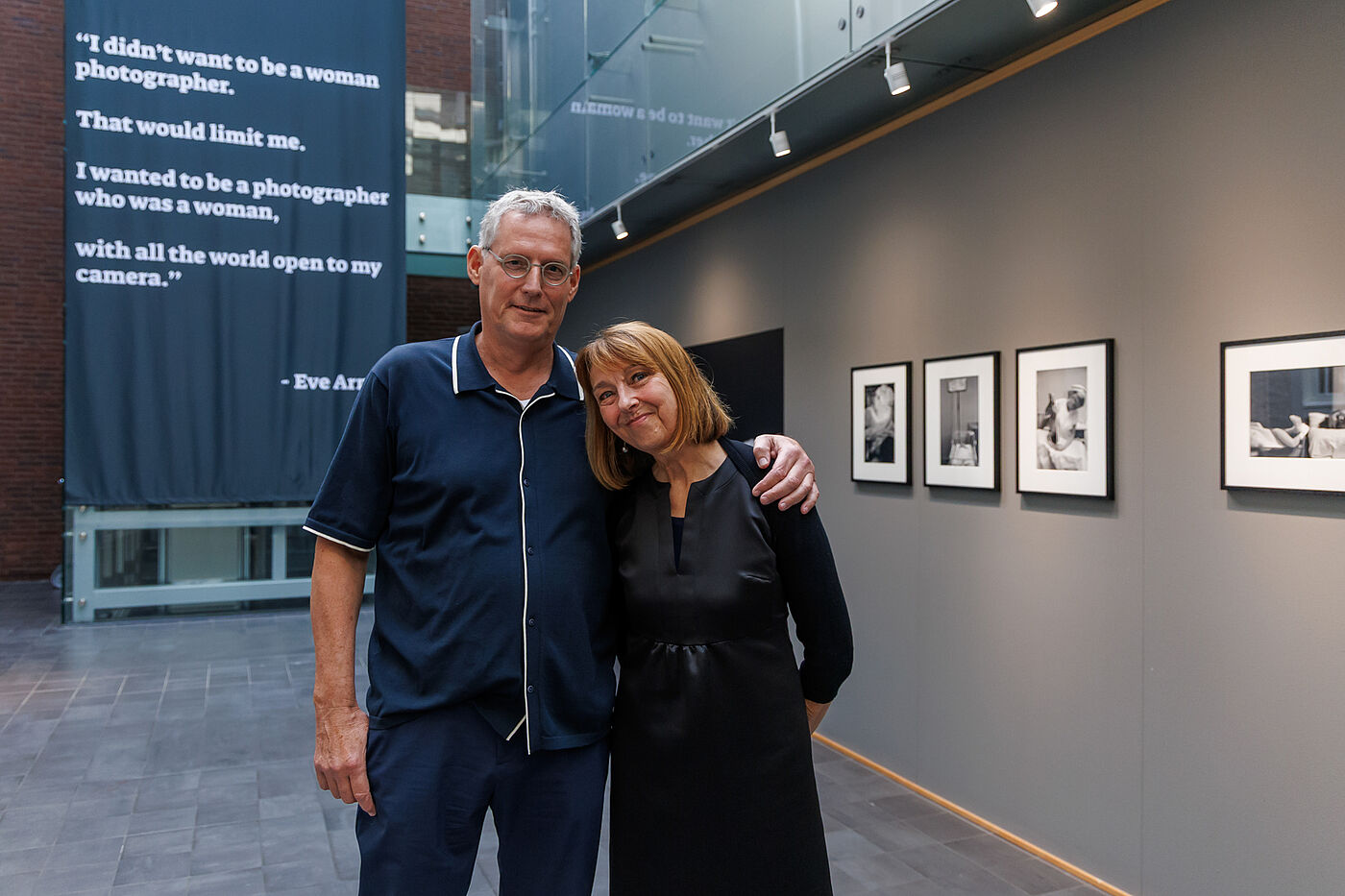 Eine Frau und ein Mann Arm in Arm in einer Ausstellung