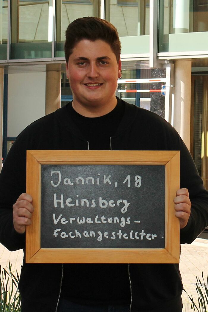 Jannik Cordewener hält Tafel mit seinem Namen, seinem Alter und seinem Ausbildungsberuf