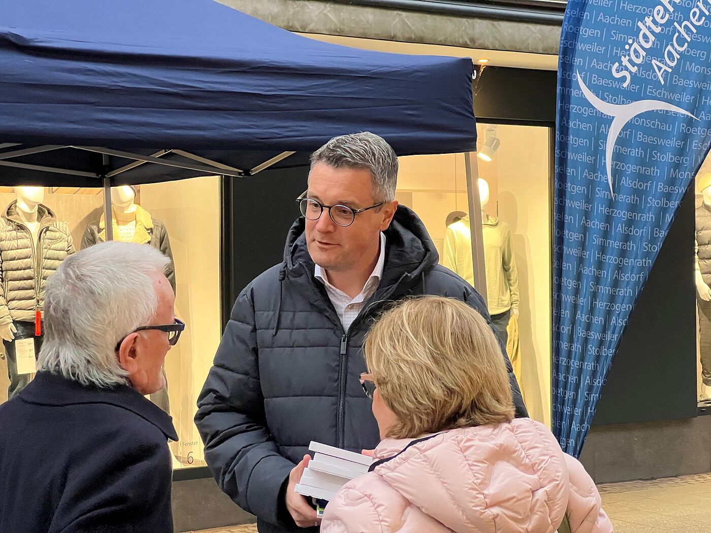 Ein Mann redet mit zwei Frauen.