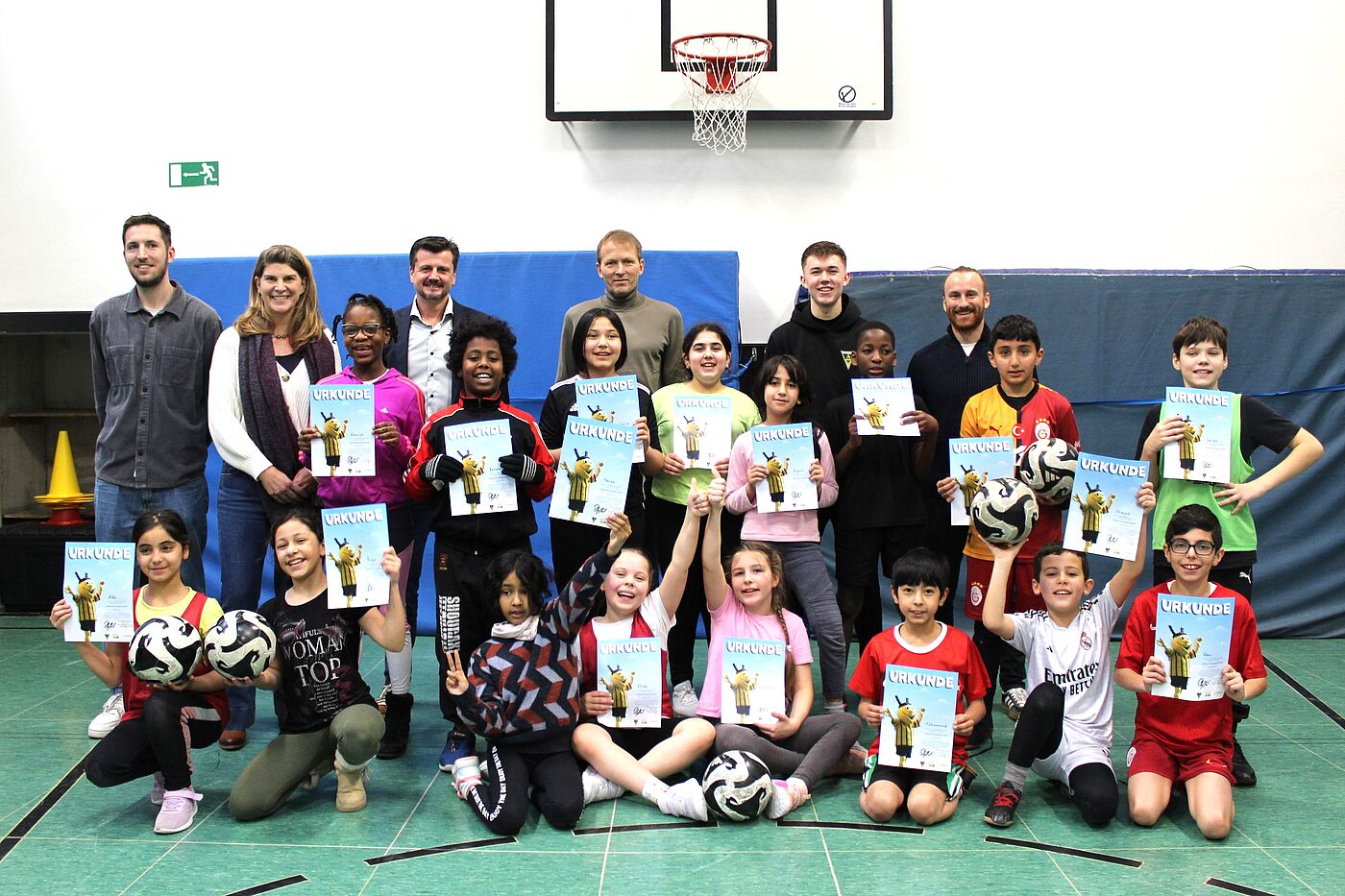 Kinder und Erwachsene in einer Sporthalle.