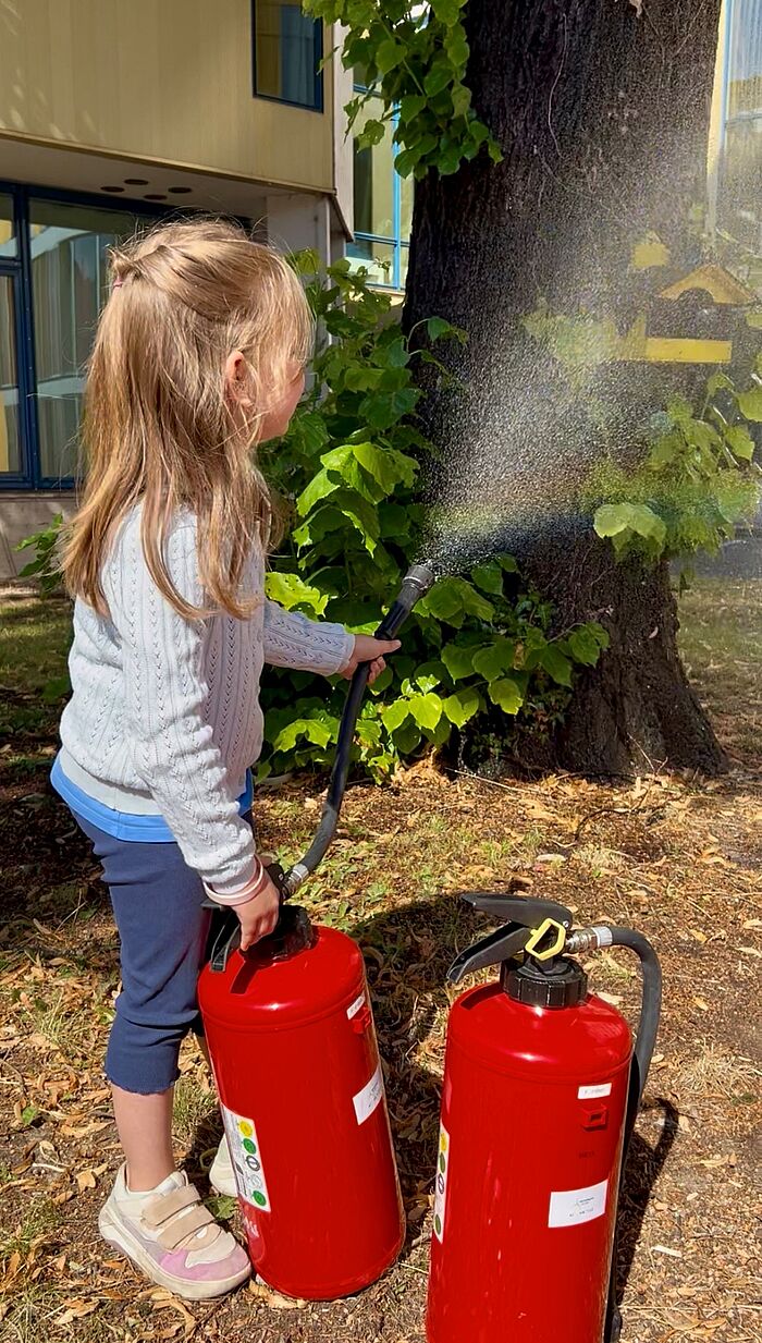 Ein Mädchen mit Feuerlöscher.