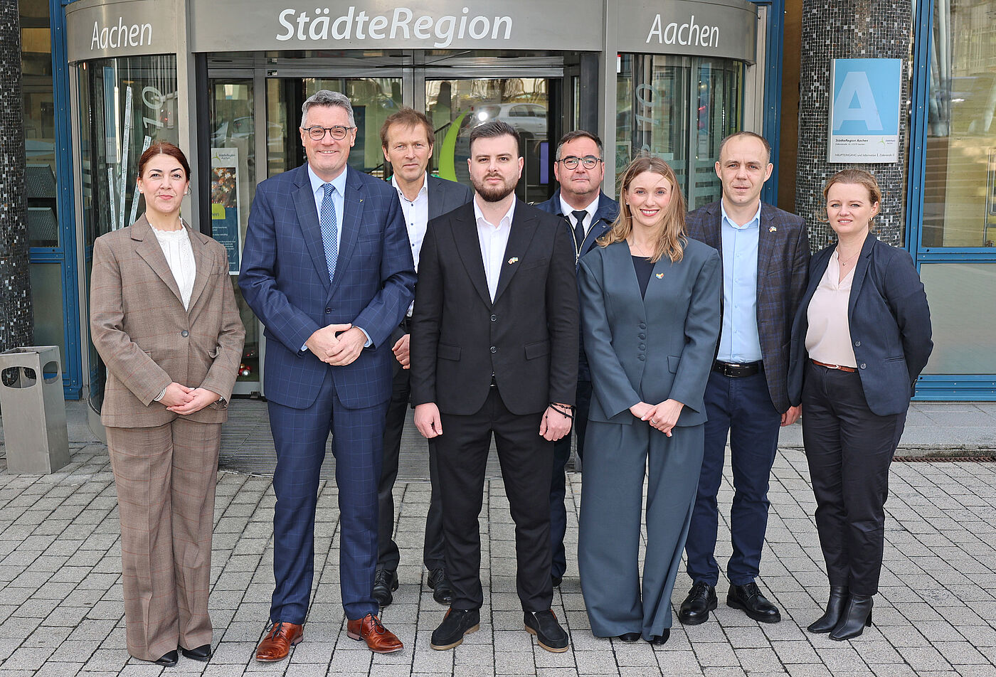 Mehrere Menschen vor einem Gebäude.