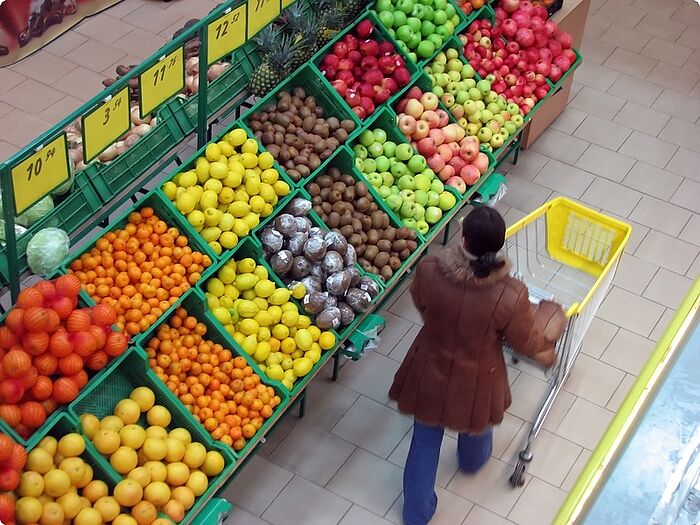 Einkaufswagen vor Gemüseregal
