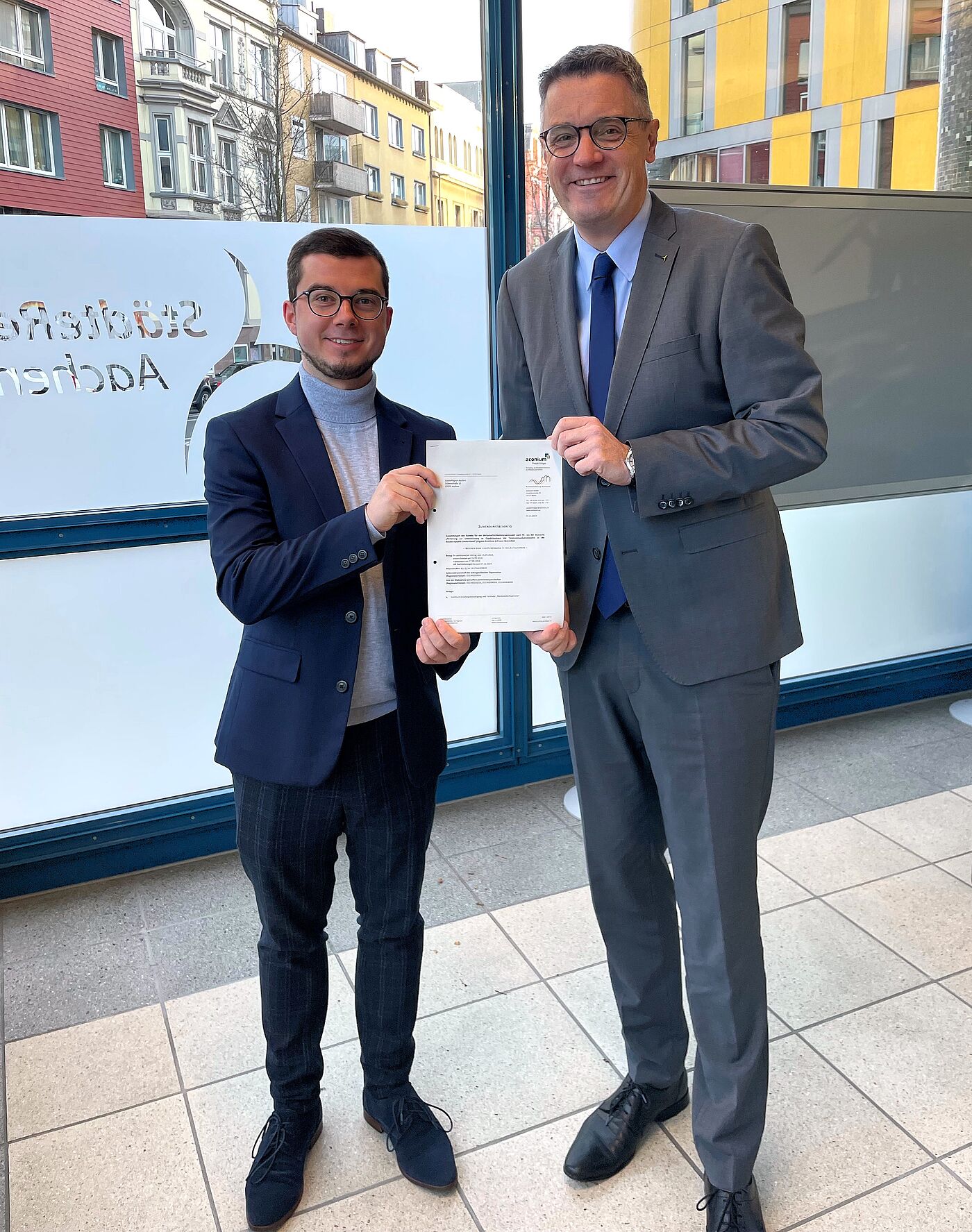 „Sie haben Post“: Städteregionsrat Dr. Tim Grüttemeier (r.) und der Gigabitkoordinator Lars Kleinsteuber freuen sich über den Zuwendungsbescheid des Bundes. Damit werden in Alsdorf, Baesweiler und Würselen die „grauen Flecken“ ohne Glasfaseranschluss geschlossen.