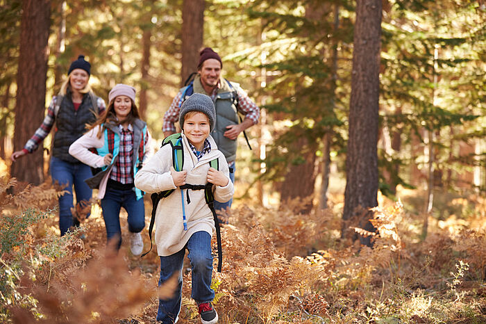 Eine Familie wandert fröhlich durch den Wald