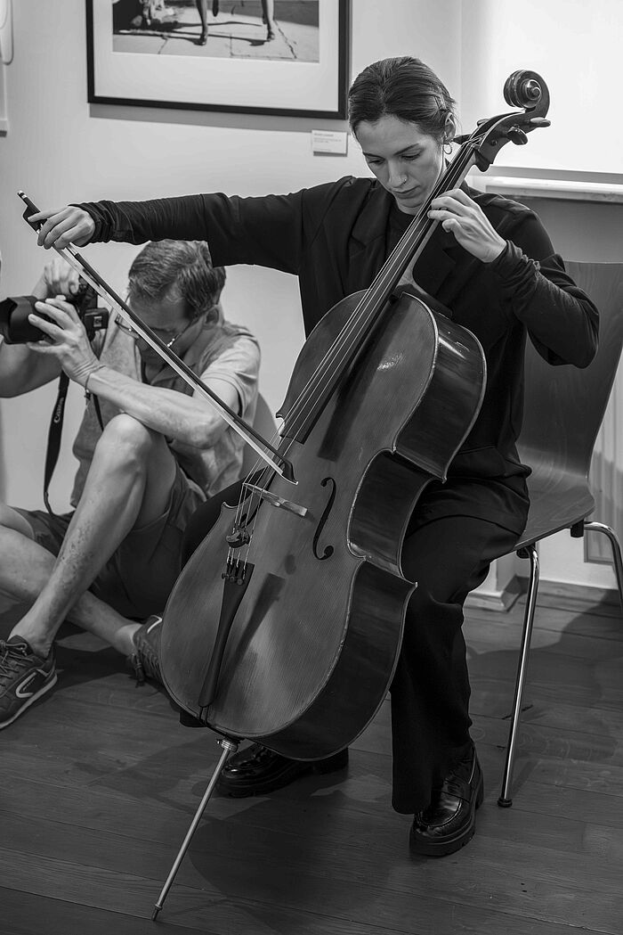 Eine Frau spielt Cello. Das Bild ist in schwarz-weiß. 
