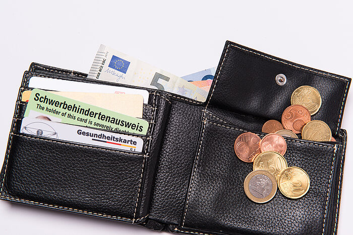 Geldbörse mit Kleingeld und neuem Schwerbehindertenausweis im Scheckkartenformat