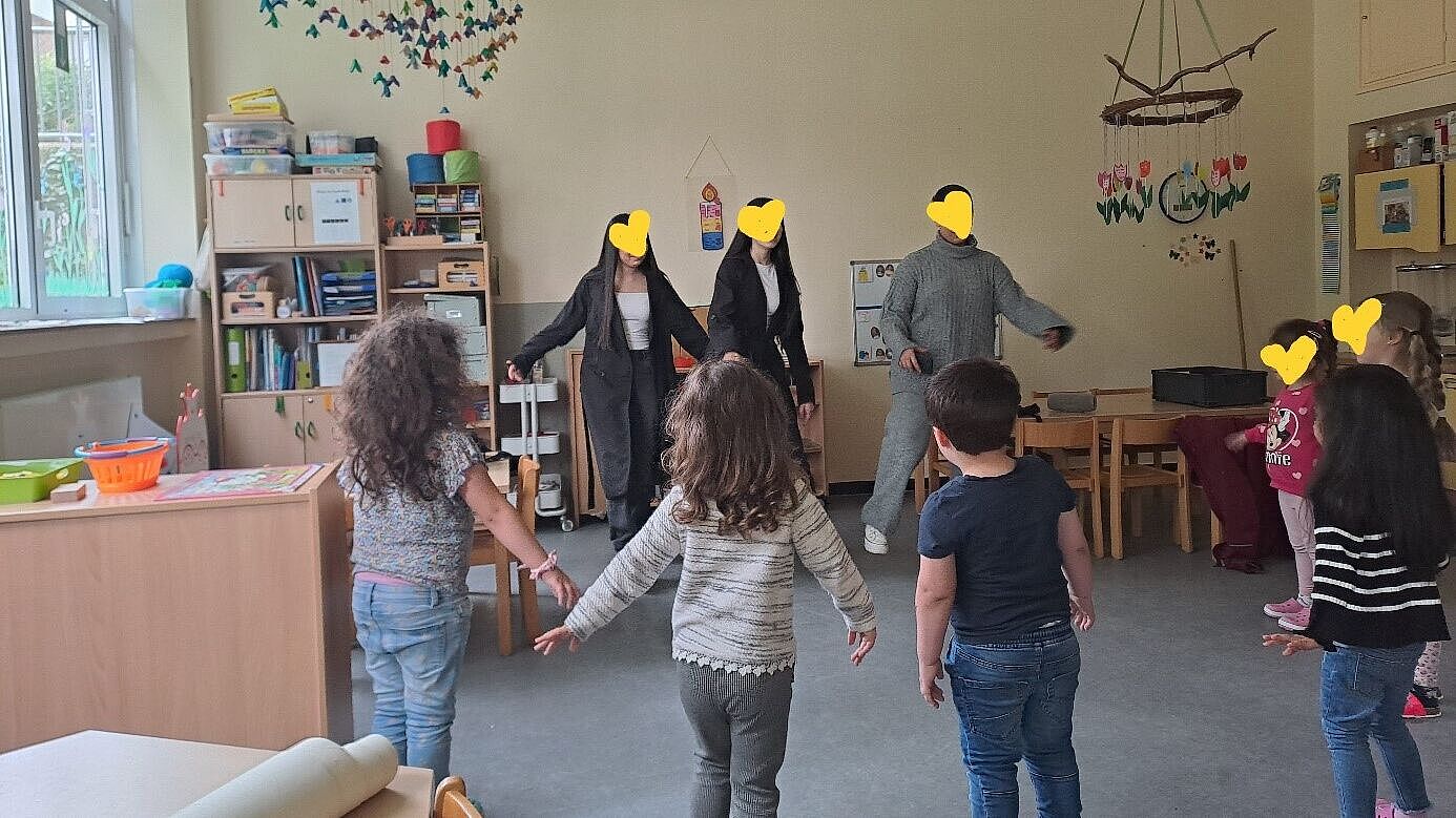 Kinder und Praktikant_innen stehen im Tanzkreis