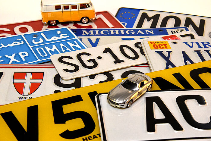 Mehrere Internationale Autokennzeichen mit Modellautos