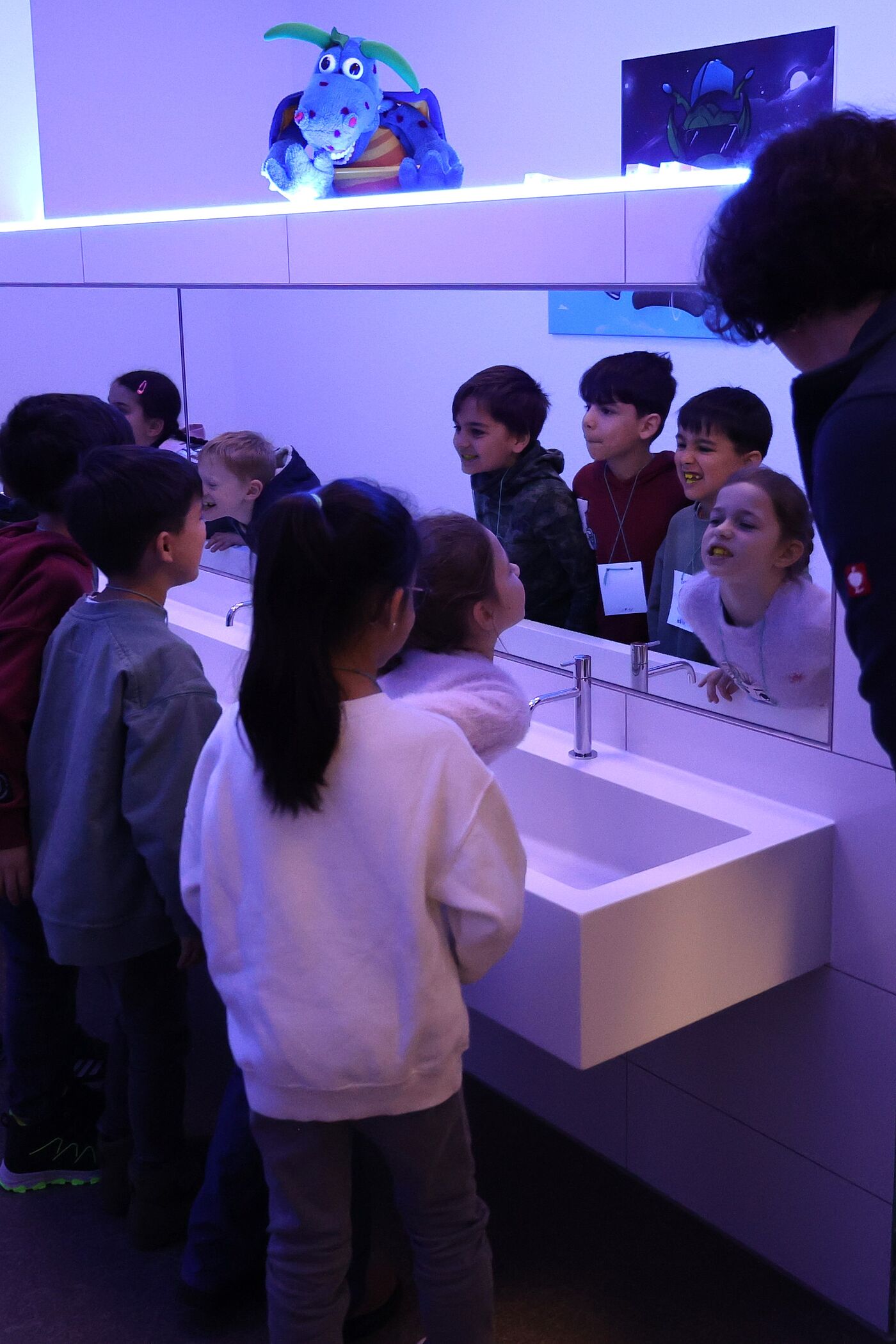 Kinder bestaunen Zahnbeläge unter Schwarzlicht