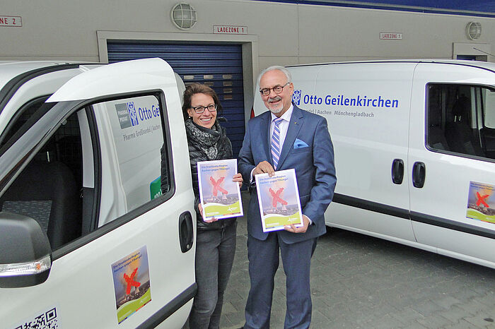 Die Mitinhaberin von Otto Geilenkirchen, Ann Dwornik, und Städteregionsrat Helmut Etschenberg präsentieren den rollenden Tihange-Protest auf den Fahrzeugen des Pharma-Großhändlers. 