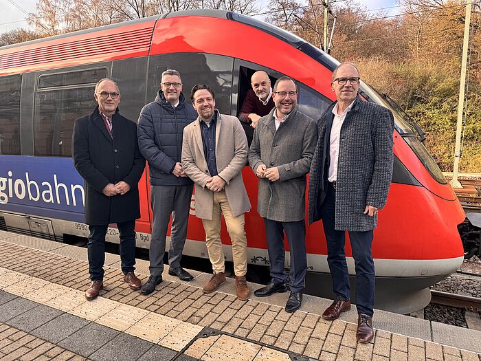 Mehrere Männer neben einem Zug.