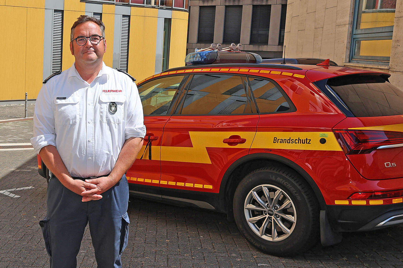 Ein Feuerwehrmann vor einem roten Einsatzwagen.