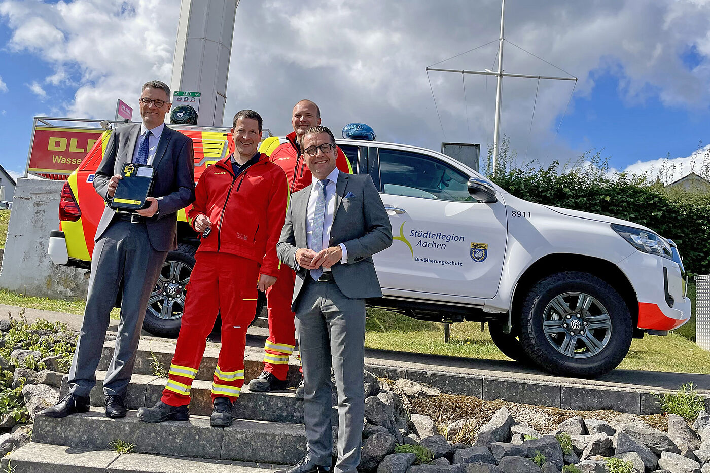 Das erste Warnfahrzeug ist einsatzbereit an Ort und Stelle in Simmerath: Bei der Schlüsselübergabe freuten sich (von links): Städteregionsrat Dr. Tim Grüttemeier, Martin Pieren und Gerald Meschke von der DLRG sowie Andreas Dovern vom Amt für Brandschutz, Rettungsdienst und Bevölkerungsschutz.