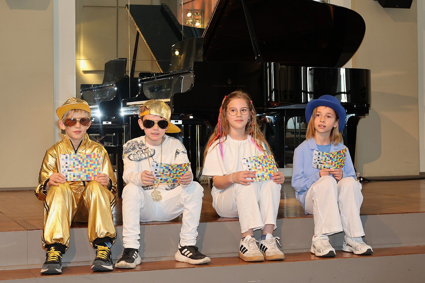 Vier Kinder in Kostümen vor einem Klavier