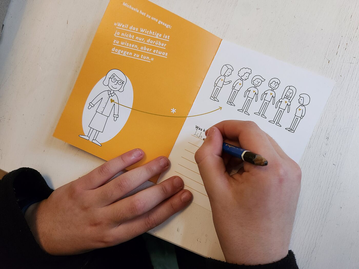 Eine Kinderhand füllt einen Zettel aus.