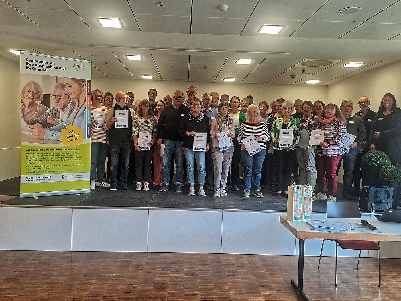 Mehrere alte Menschen stehen auf einem Gruppenbild beisammen.