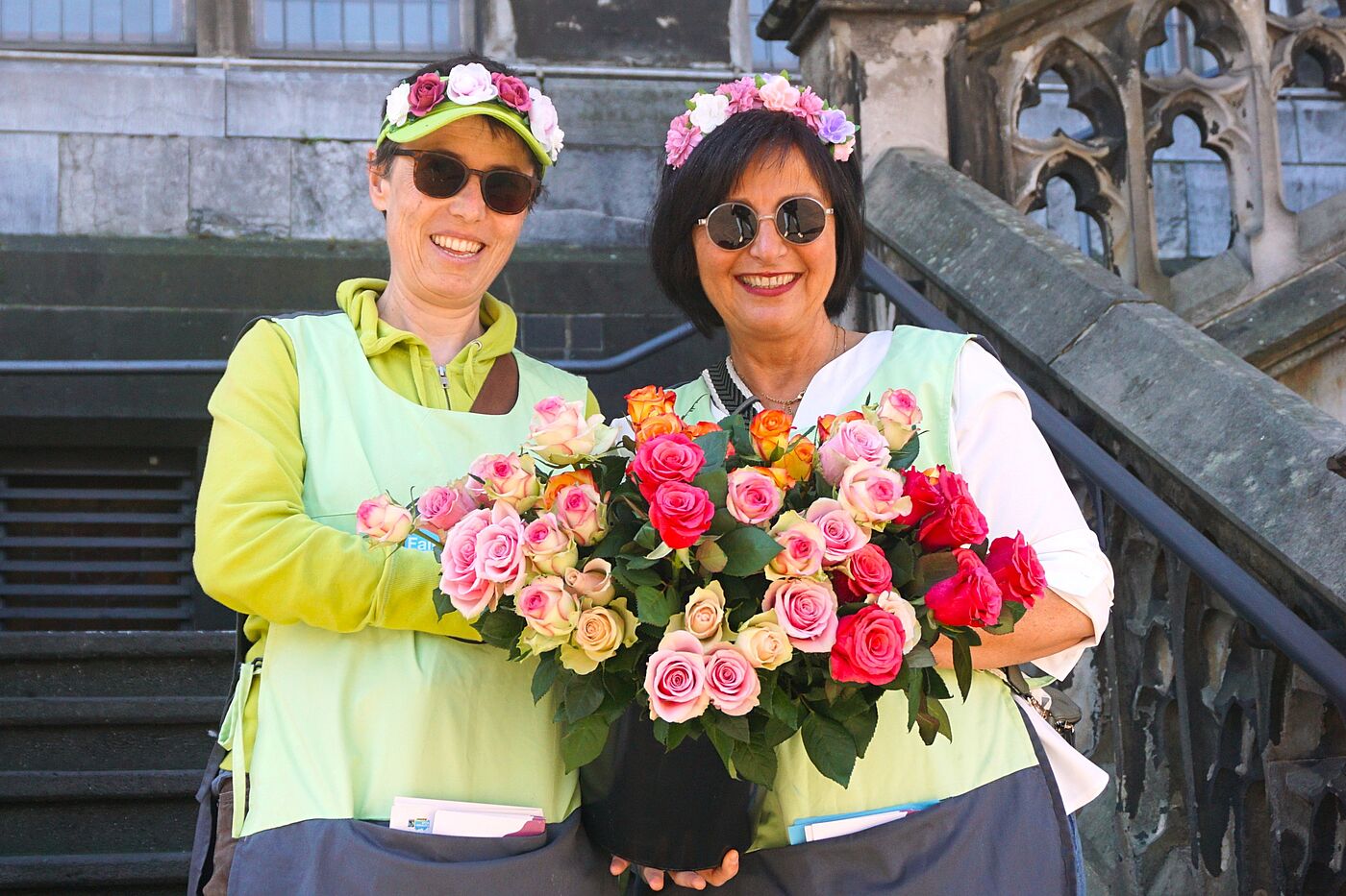 Zwei Frauen mit Rosen in der Hand.