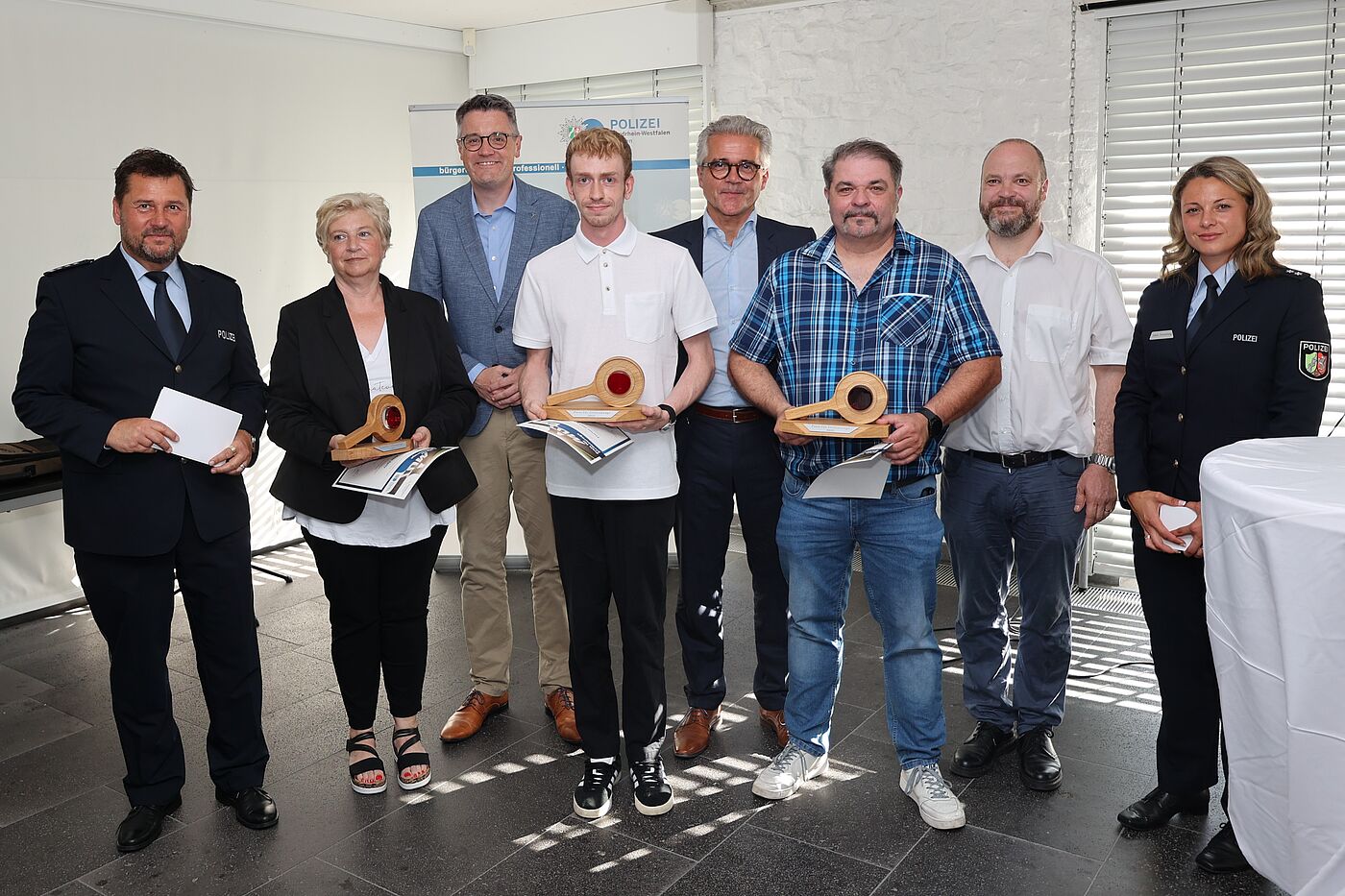 Mehrere Menschen, darunter Polizisten, stehen nebeneinander.