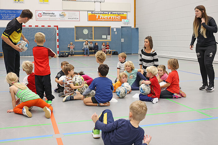 Die Kinder der Roetgener Kita „Wackelzahn“ hatten 2022 im Rahmen der städteregionalen Bildungszugabe Alemannia Aachen zu Gast in der Sporthalle. Tobias Sterck (links) erklärt den Kindern und den Erzieherinnen der Kita Wackelzahn (rechts: Jill Dickeler) die nächste Übung.