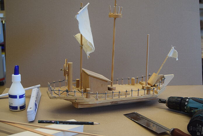 Das Bild zeigt ein kleines Spielzeugschiff auf einem Tisch