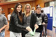 2 Schülerinnen werfen Ihren Wahlzettel in die Urne