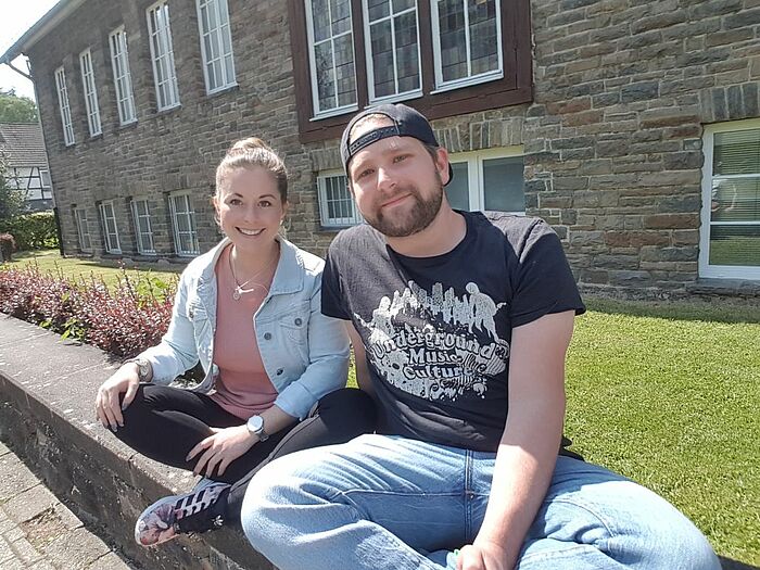 Lara Brammertz und Domenik Delsemmé sitzen auf einer Mauer