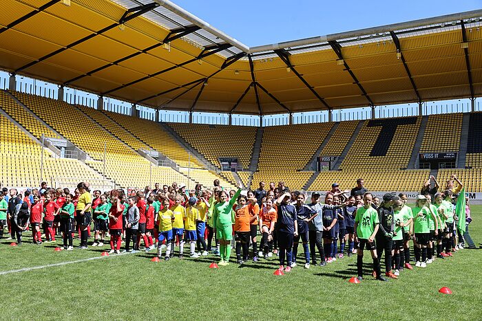 Grundschulkinder stehen auf dem Rasen vom Stadion Tivoli und freuen sich über die Siegerehrung der Städteregionsmeisterschaft.