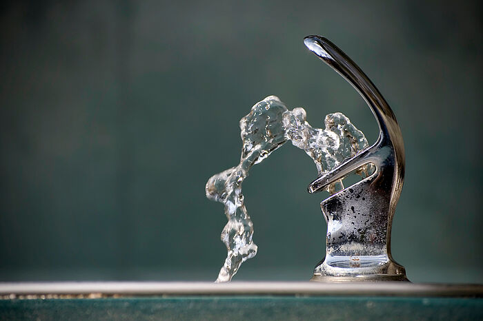 Trinkwasser fließt in einer Fontaine aus einem Wasserspender