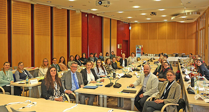 Viele Menschen in einem Sitzungssaal.