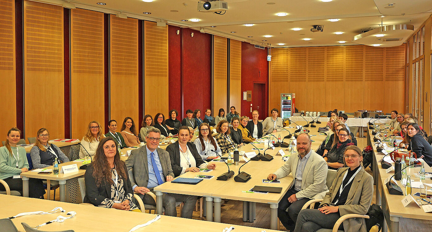 Viele Menschen in einem Sitzungssaal.