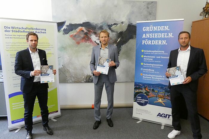 Herr Pennings, Herr Terodde und Herr Gastes stehen mit dem Bericht in der Hand in Herrn Teroddes Büro.