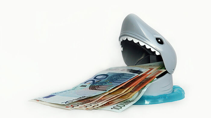 Geldfressender Hai als Symbol für eine Kostenfalle