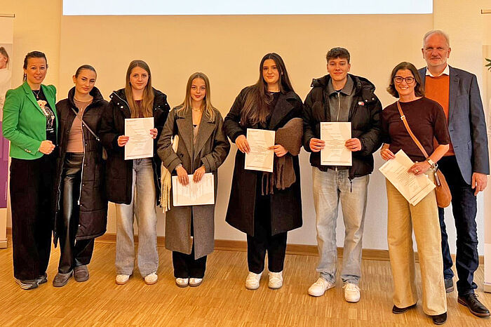 Junge Menschen mit Urkunden in der Hand.