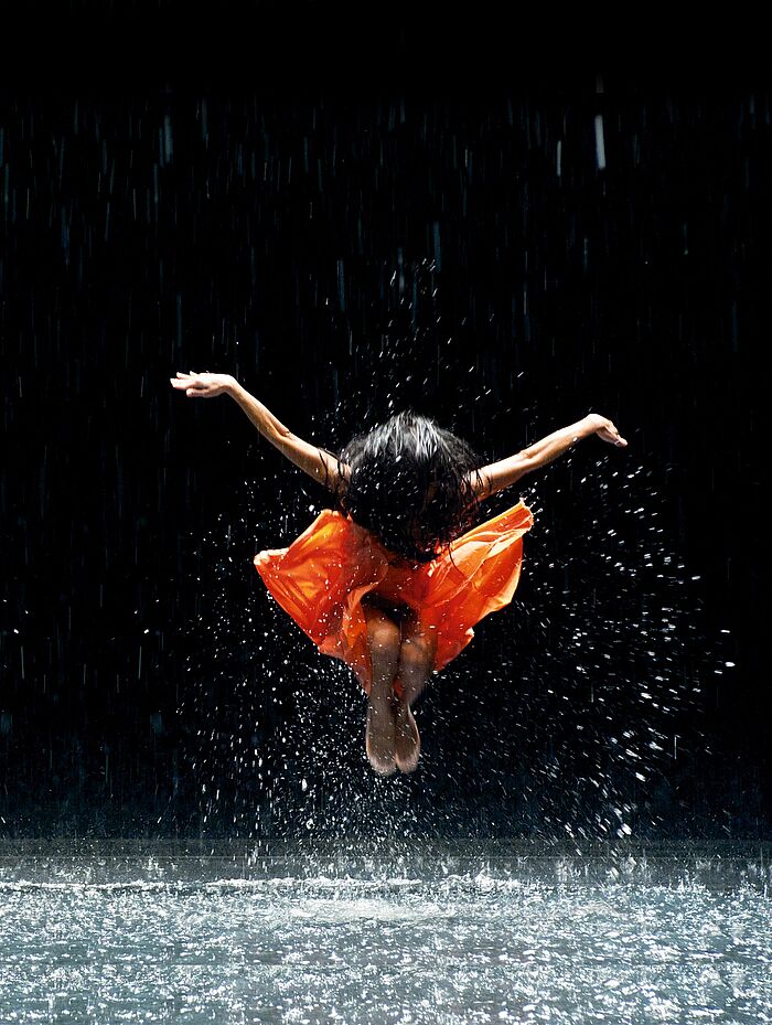 Tanzszene mit Sprung und Wasser, Aufführung der Pina Bausch Tänzer_innen