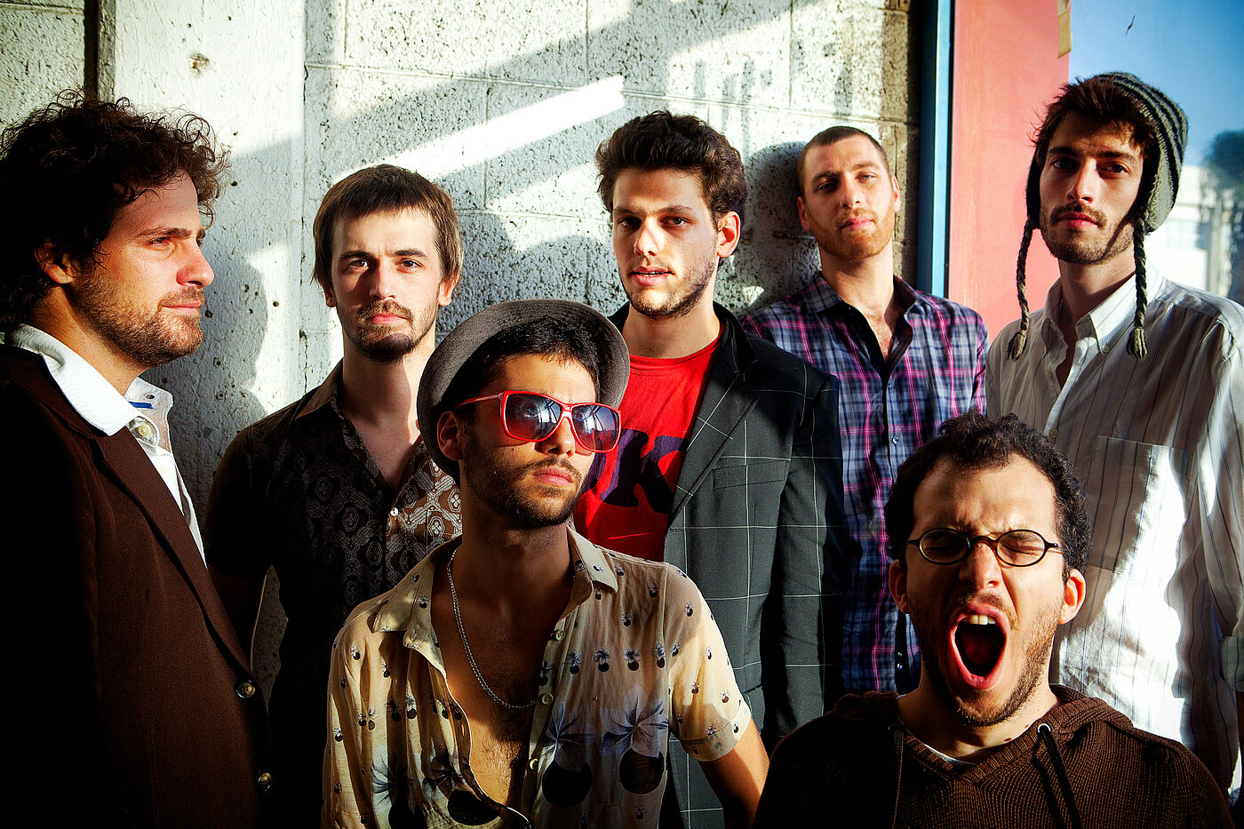 Sieben Männer blicken in die Kamera.